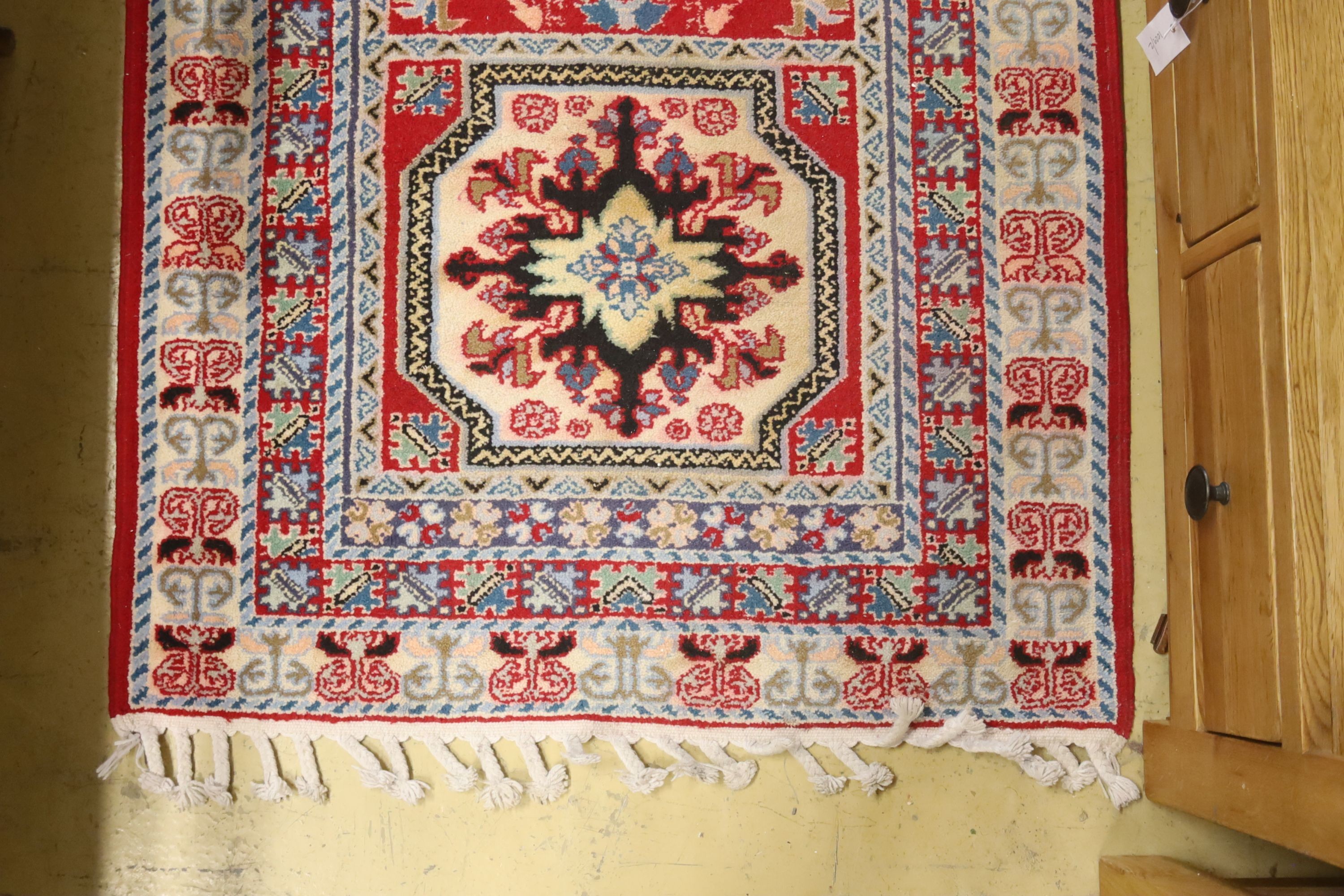 A Kazak style ivory ground rug, 144 x 64cm